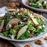 A vibrant Frisée Pear Blue Cheese Bowl tossed with a light vinaigrette and toasted walnuts, ready to serve.