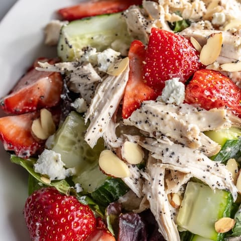 Tender poached chicken breast, juicy strawberries, and crunchy almonds mixed with feta and greens for a vibrant Strawberry Poppy Seed Chicken Salad.