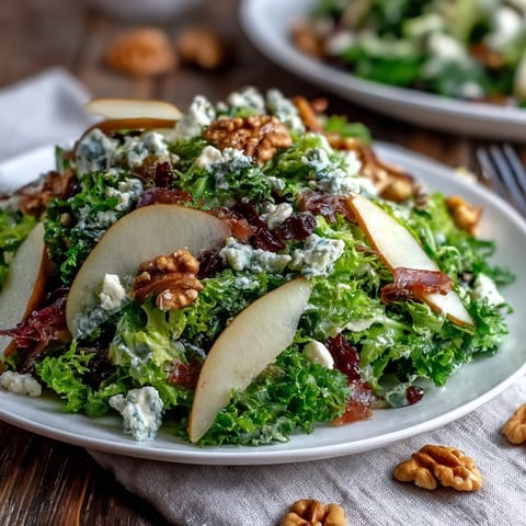 A vibrant Frisée Pear Blue Cheese Bowl tossed with a light vinaigrette and toasted walnuts, ready to serve.