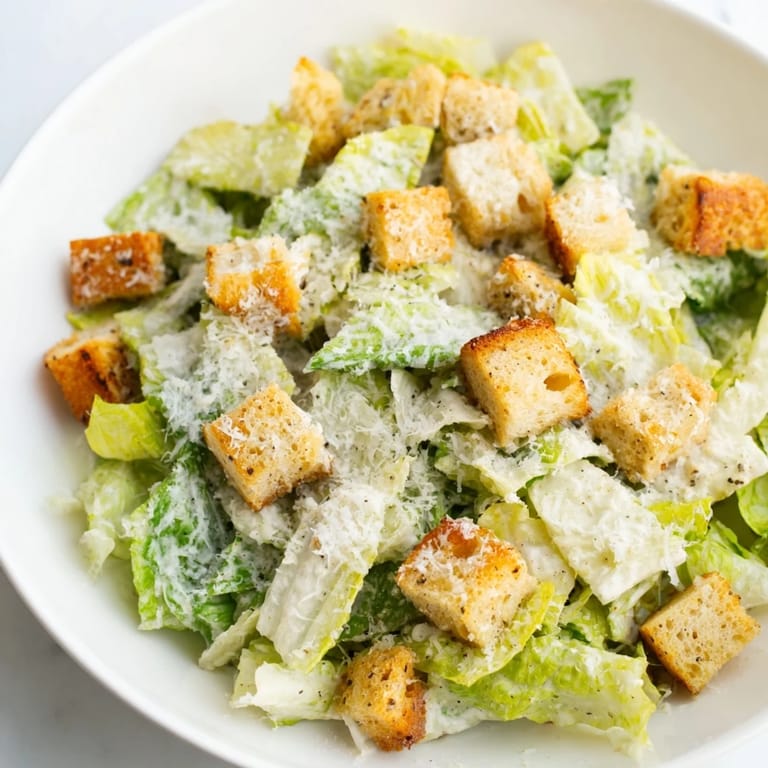 A vibrant bowl of Caesar salad features crisp romaine lettuce, ready to enjoy as a side.