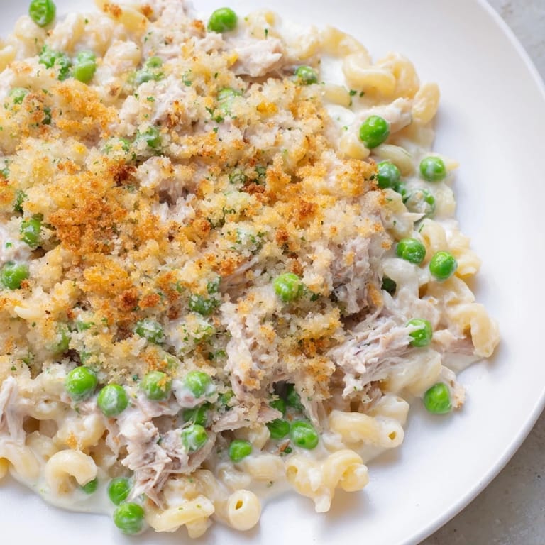 Creamy tuna casserole, featuring tender noodles, peas, and flaky tuna, freshly baked and ready to eat.