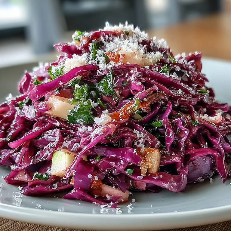 Shredded red cabbage and green apple tossed with Parmesan and a tangy vinaigrette on a rustic platter.